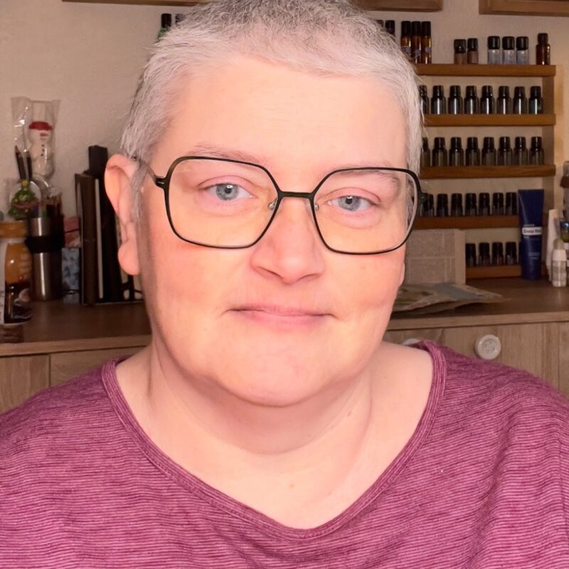 Herzliches Porträt der Künstlerin Karin Haas in ihrem Atelier, wie sie nachhaltige Kunst aus Pappe gestaltet
